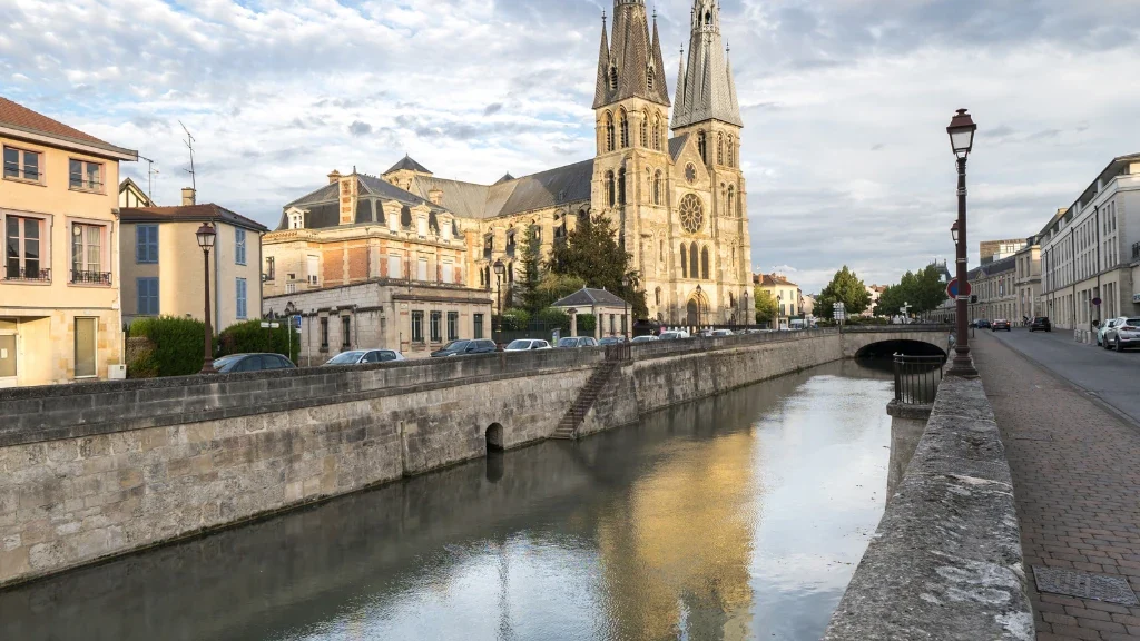 Vue aérienne d'un quartier résidentiel avec maisons et routes, sous un ciel bleu.