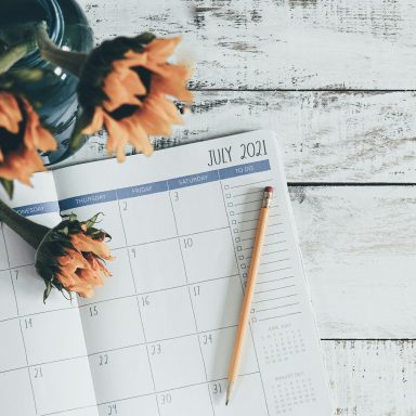 Calendrier de juin 2023 avec un crayon orange et des fleurs jaunes en vase.